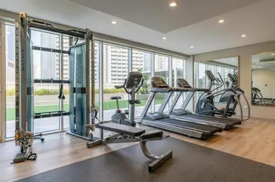 a gym with treadmills and ellipticals in a building at Modern 1BR Apt - Canal View in Dubai
