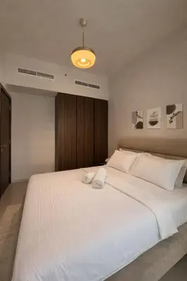 a bedroom with a large bed with white sheets at Modern 1BR Apt - Canal View in Dubai