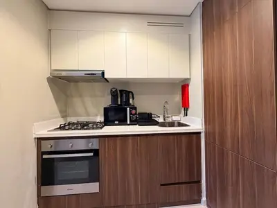 a small kitchen with a stove and a sink at Modern 1BR Apt - Canal View in Dubai