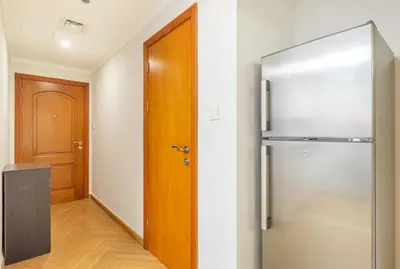a refrigerator in a room with a wooden door at Luxury 2BR in Dubai Marina Man 1014 in Dubai