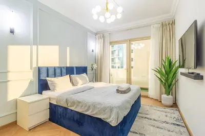 a bedroom with a blue bed and a tv at Luxury 2BR in Dubai Marina Man 1014 in Dubai