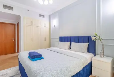 a bedroom with a large bed with a blue headboard at Luxury 2BR in Dubai Marina Man 1014 in Dubai