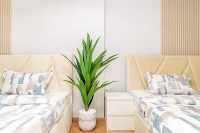 two beds in a room with a potted plant at Luxury 2BR in Dubai Marina Man 1105 in Dubai