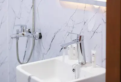 a white bathroom with a sink and a shower at Luxury 2BR in Dubai Marina Man 1105 in Dubai