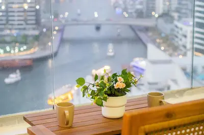 a vase with flowers sitting on a table in front of a window at 3BHK and Floating Bed in Dubai Marina w View DEC 1707 in Dubai