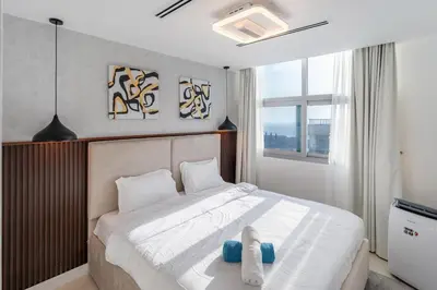 a bedroom with a white bed and a window at Luxury 3 BR w Floating Bed in Dubai Marina DEC 902 in Dubai