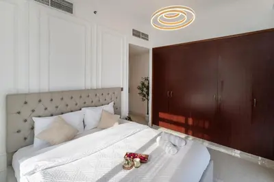 a bedroom with a large white bed with a brown headboard at Luxury 3 BR w Floating Bed in Dubai Marina DEC 902 in Dubai
