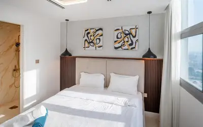 a bedroom with a bed with white sheets and pillows at Luxury 3 BR w Floating Bed in Dubai Marina DEC 902 in Dubai