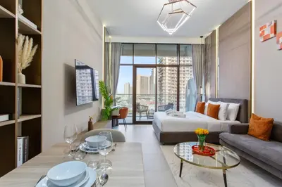 a living room with a couch and a table at Chic & Sleek Studio in Westwood Grande in Dubai