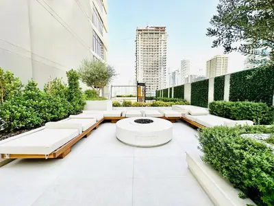 a courtyard with white benches and a fountain at Chic & Sleek Studio in Westwood Grande in Dubai