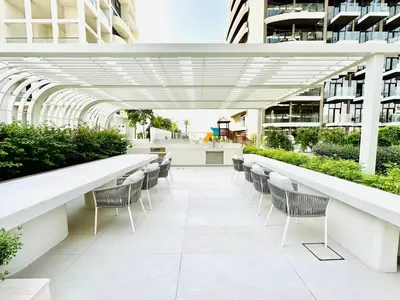 a patio with chairs and tables in a building at Chic & Sleek Studio in Westwood Grande in Dubai
