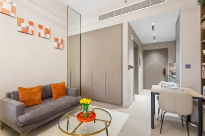 a living room with a couch and a table at Chic & Sleek Studio in Westwood Grande in Dubai