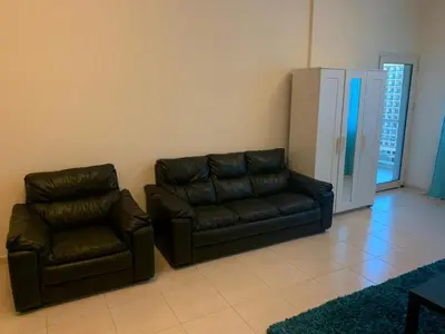 a living room with a couch and a refrigerator at Dubai Sports City home in Peaceful Location in Dubai