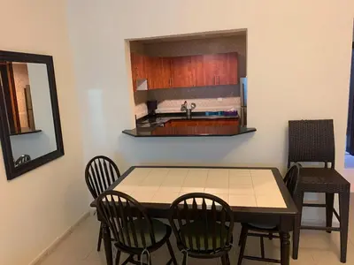 a kitchen with a table and chairs and a sink at Dubai Sports City home in Peaceful Location in Dubai