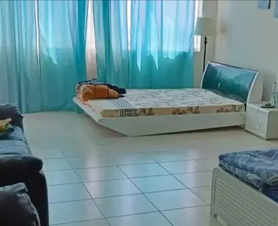 a bedroom with a bed and a blue curtain at Dubai Sports City home in Peaceful Location in Dubai