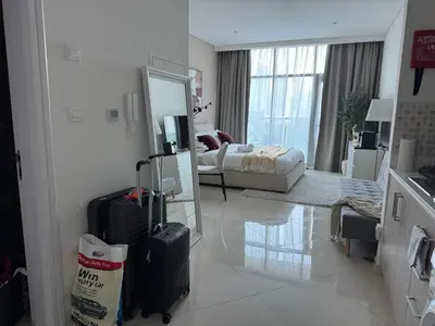 a living room with luggage and a room with a bed at Comfortable apartments on the Palm in Dubai