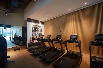 a gym with a row of treadmills and a sign at Comfortable apartments on the Palm in Dubai