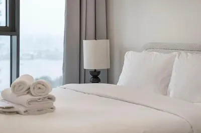 a white bed with towels on it with a window at Luxury 3 Bedroom Apartment in Creek Harbour in Dubai