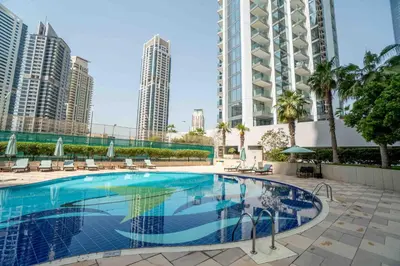 a swimming pool in the middle of a city with tall buildings at Elegant 1-BDR with Panoramic Marina & Canal Views in Dubai
