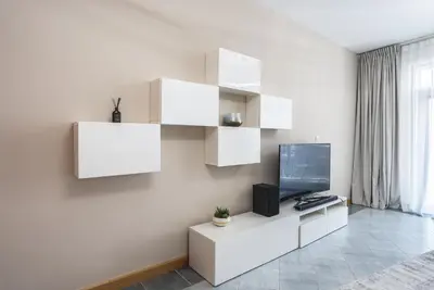 a living room with white cabinets and a television at Elegant 1-BDR with Panoramic Marina & Canal Views in Dubai