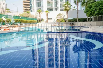 a swimming pool with a reflection in the water at Elegant 1-BDR with Panoramic Marina & Canal Views in Dubai
