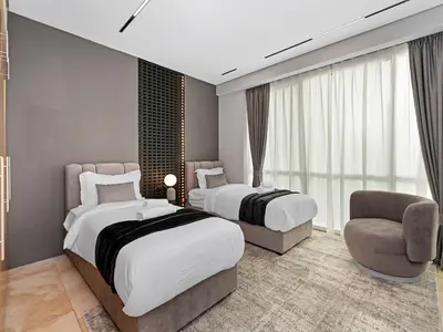 a hotel room with two beds and a chair at MegaLuxury Beachfront with Panoramic Ain Dubai Views in JBR, Sleep 12 in Dubai