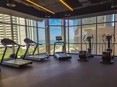 a gym with cardio equipment in a building with windows at MegaLuxury Beachfront with Panoramic Ain Dubai Views in JBR, Sleep 12 in Dubai