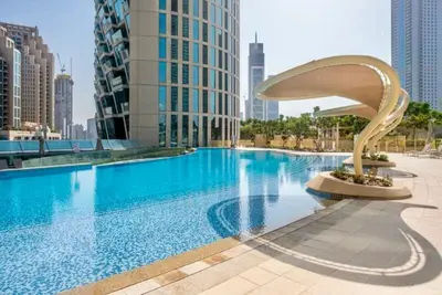 a large swimming pool in a city with tall buildings at Nivis find-3BHK Apartment-Burj vista- Connected to Dubai Mall in Dubai