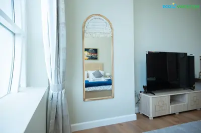 a bedroom with a mirror and a tv at Eco-Luxe Retreat - Minutes from Global Village in Dubai