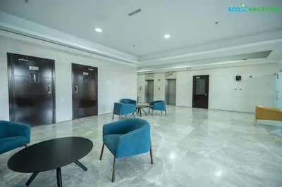 a waiting room with blue chairs and tables in a building at Eco-Luxe Retreat - Minutes from Global Village in Dubai