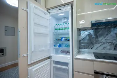 an empty refrigerator with its door open in a kitchen at Eco-Luxe Retreat - Minutes from Global Village in Dubai