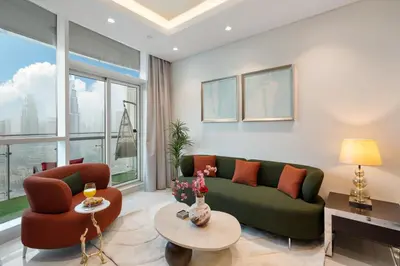 a living room with a green couch and orange chairs at Full Burj Khalifa View New Year Fireworks - DAMAC Maison Distinction in Dubai