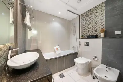 a bathroom with a sink and a toilet and a tub at Full Burj Khalifa View New Year Fireworks - DAMAC Maison Distinction in Dubai