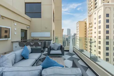 a balcony with couches and chairs on a building at Stunning VIP Penthouse JBR cinema&spa&pool in Dubai