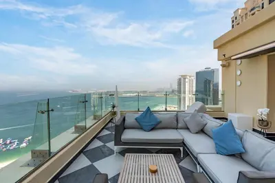 a balcony with a couch and a view of the ocean at Stunning VIP Penthouse JBR cinema&spa&pool in Dubai