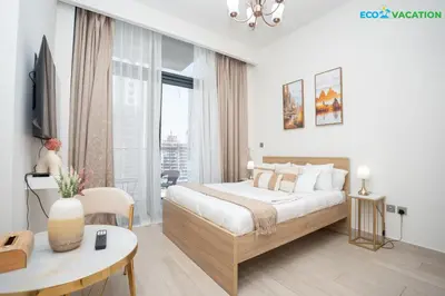 a white bedroom with a large bed and a table at Riviera Haven Boutique Stay with Wooden Charm in Dubai