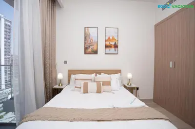 a bedroom with a bed with white sheets and pillows at Riviera Haven Boutique Stay with Wooden Charm in Dubai