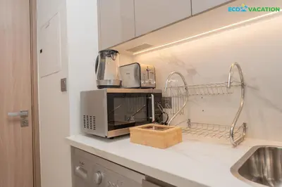 a kitchen with a microwave on a counter at Riviera Haven Boutique Stay with Wooden Charm in Dubai