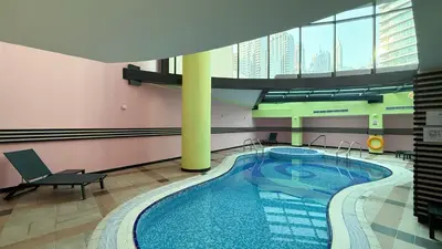 a large swimming pool in a building with a building at Modern 1BR Apartment - Marina Walk in Dubai