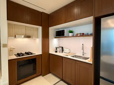 a kitchen with wooden cabinets and a sink at Coastal Chic at Emaar Beachfront 1BR in Dubai