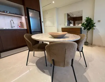 a kitchen with a table with chairs and a bowl on it at Coastal Chic at Emaar Beachfront 1BR in Dubai