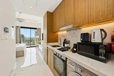 a kitchen with a sink and a microwave at Estudio Coral en Dubai By BeBalmy in Dubai