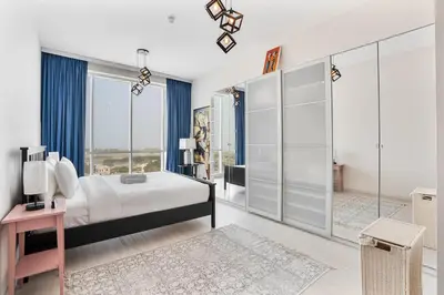 a bedroom with a bed and a large window at Beachside Bliss With Stylish 2BR with Panoramic View in Dubai