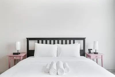 a bed with two pairs of white towels on it at Beachside Bliss With Stylish 2BR with Panoramic View in Dubai