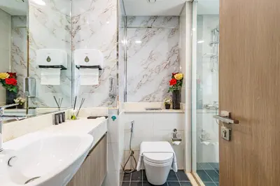 a bathroom with a toilet and a sink and a shower at The Urban Retreat Elegant 3BR Townhouse Villanova in Dubai