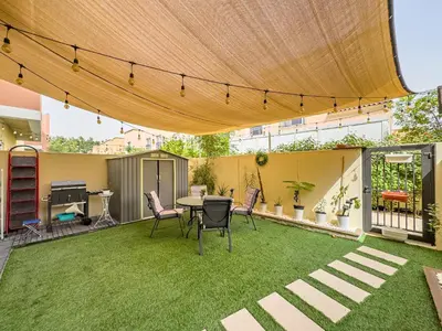 a patio with a table and chairs in a yard at The Urban Retreat Elegant 3BR Townhouse Villanova in Dubai