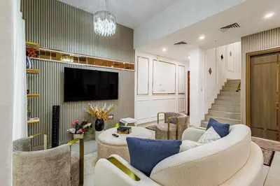 a living room with two couches and a tv at The Urban Retreat Elegant 3BR Townhouse Villanova in Dubai