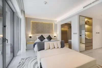 a bedroom with a large white bed with pillows at Vogue Downtown Emaar Residence Fashion Avenue with Direct Access to Dubai Mall, Studio Apartment with Balcony Overlooking Burj Khalifa View, Access to all Amenitties in Dubai