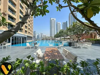 a pool with chairs and tables in a building at Vogue Downtown Emaar Residence Fashion Avenue with Direct Access to Dubai Mall, Studio Apartment with Balcony Overlooking Burj Khalifa View, Access to all Amenitties in Dubai