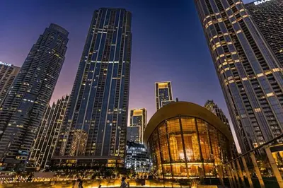 a group of tall buildings in a city at night at Vogue Downtown Emaar Residence Fashion Avenue with Direct Access to Dubai Mall, Studio Apartment with Balcony Overlooking Burj Khalifa View, Access to all Amenitties in Dubai